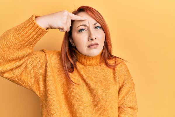 acne facial birmingham - pointing unhappy to pimple on forehead