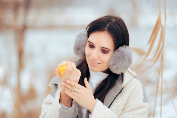 Woman Using Moisturizing Cream In Her Hands During Winter