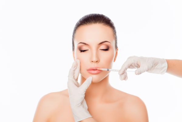 botox windsor - Doctor in gloves giving woman botox injections in lips
